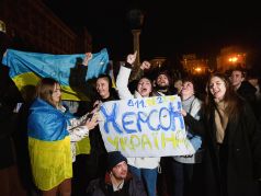 Люди в центре Киева держат транспарант с надписью 