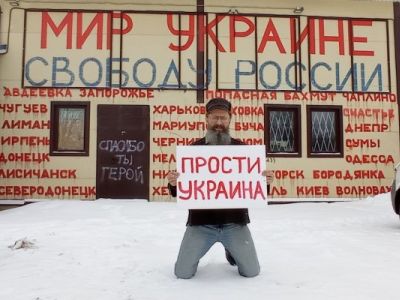 Дмитрий Скурихин с плакатом "Прости, Украина". Фото: Ульяна Скурихина